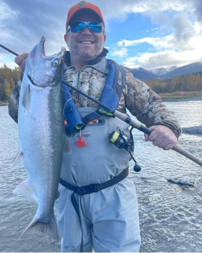 A person holding a silver salmon