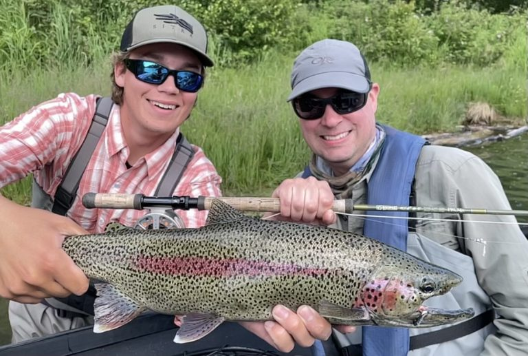 Two anglers are holding rainbow trout they caught on the Kenai River