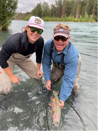 Two anglers are pictured catching rainbow trout from the Kenai River