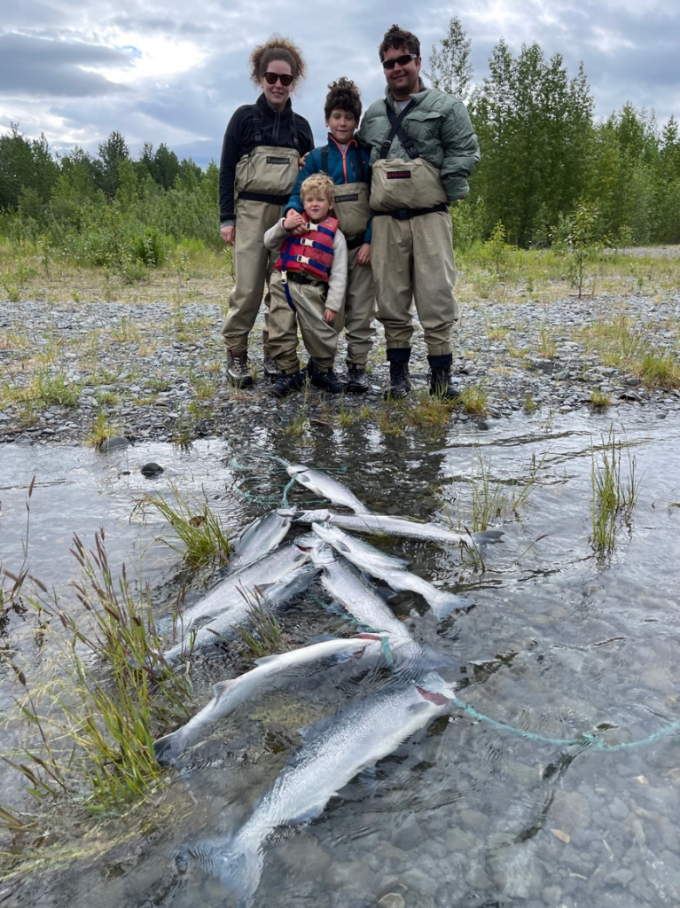 A family is posing with the fish they caught