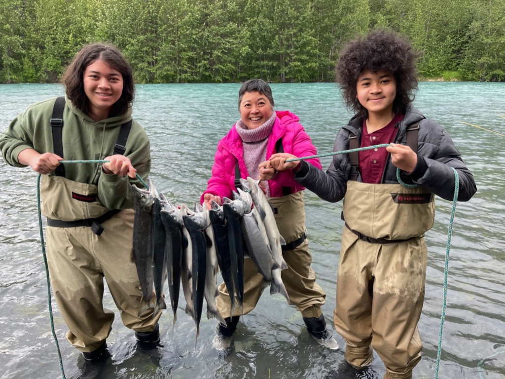 Three women posing with the fish they caught in the Kenai River
