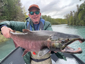 An angler holding a giant silver salmon caught in the Kenai River.